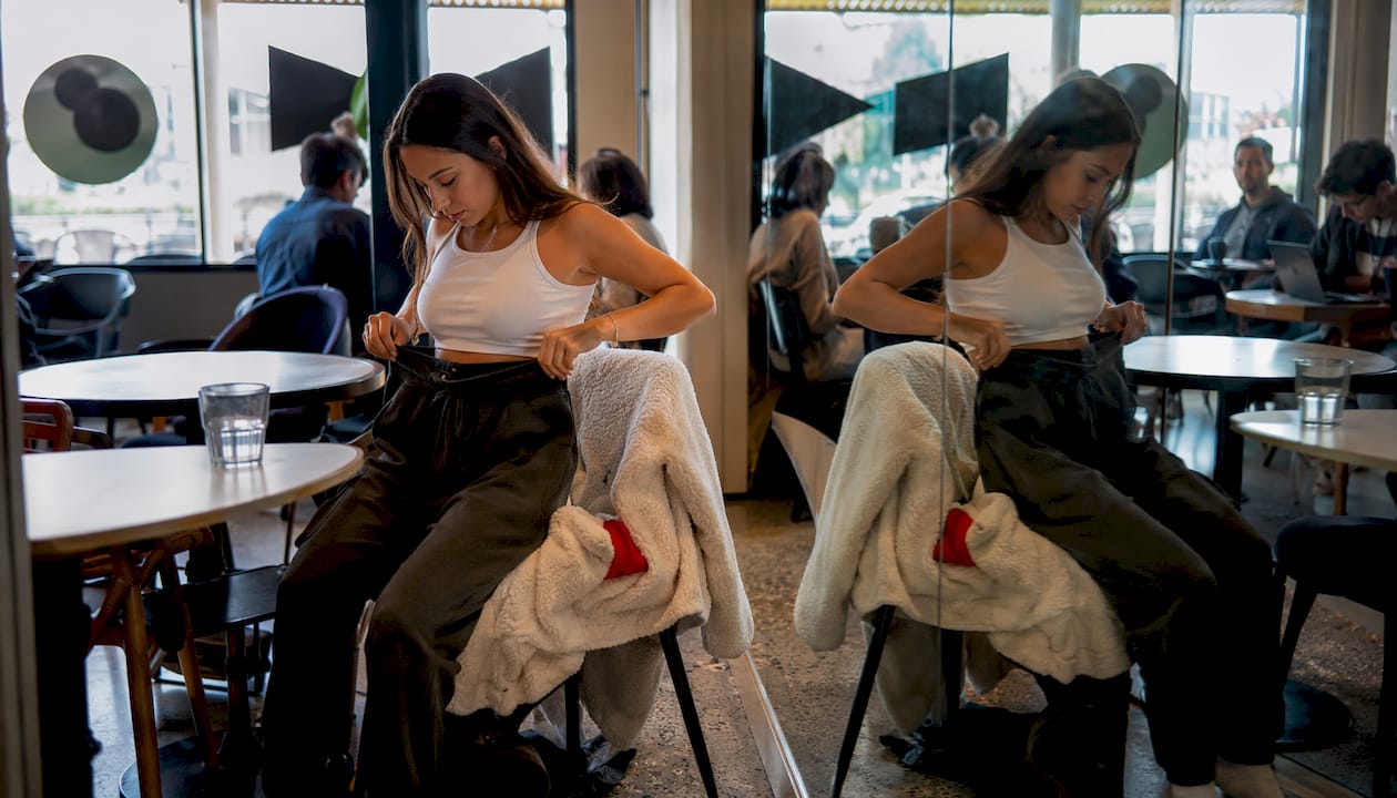 Woman comparing joggers and sweatpants in mirror