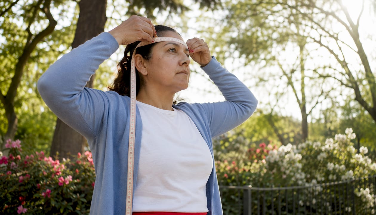 Woman measuring head circumference with tape